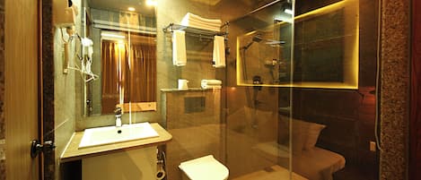 A modern bathroom with a glass-enclosed shower, a sink, and a toilet.