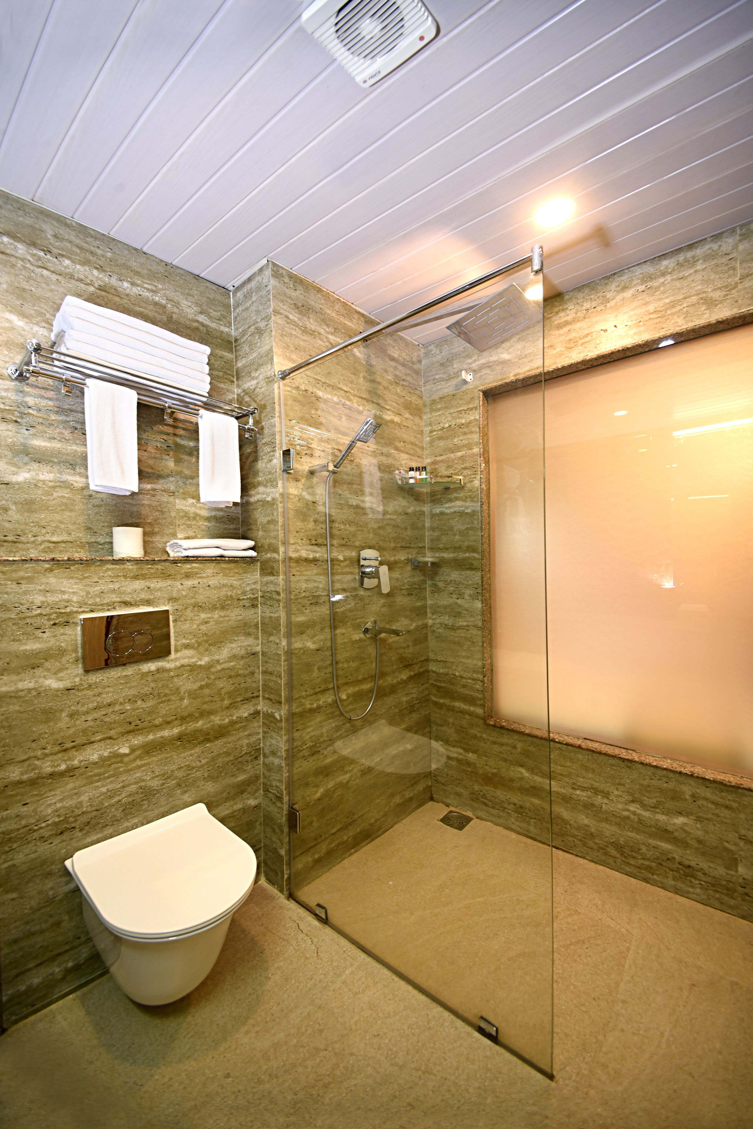 Une salle de bain moderne avec une douche à parois de verre, des toilettes et un porte-serviettes.