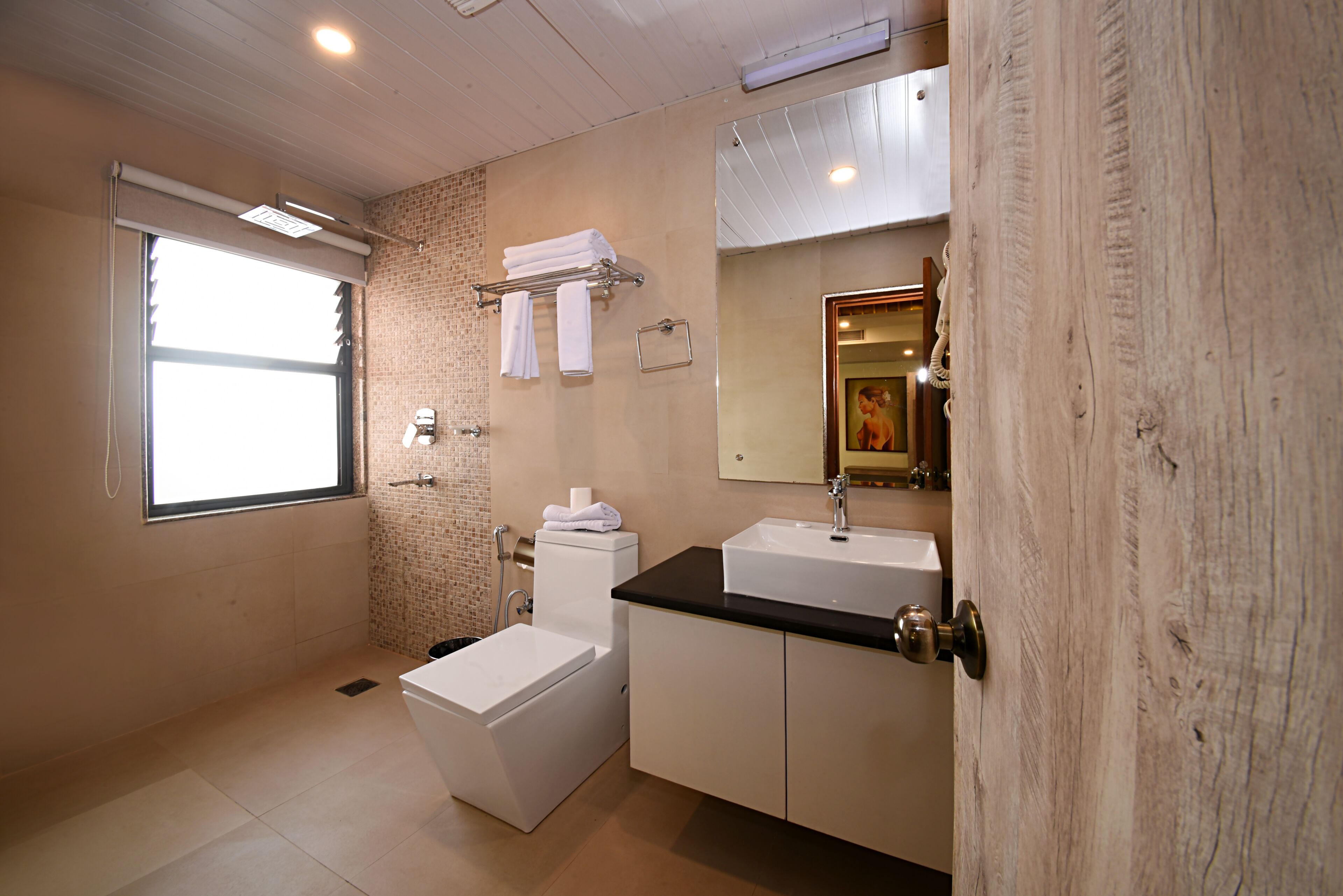 A bathroom with a toilet, sink, and a window.