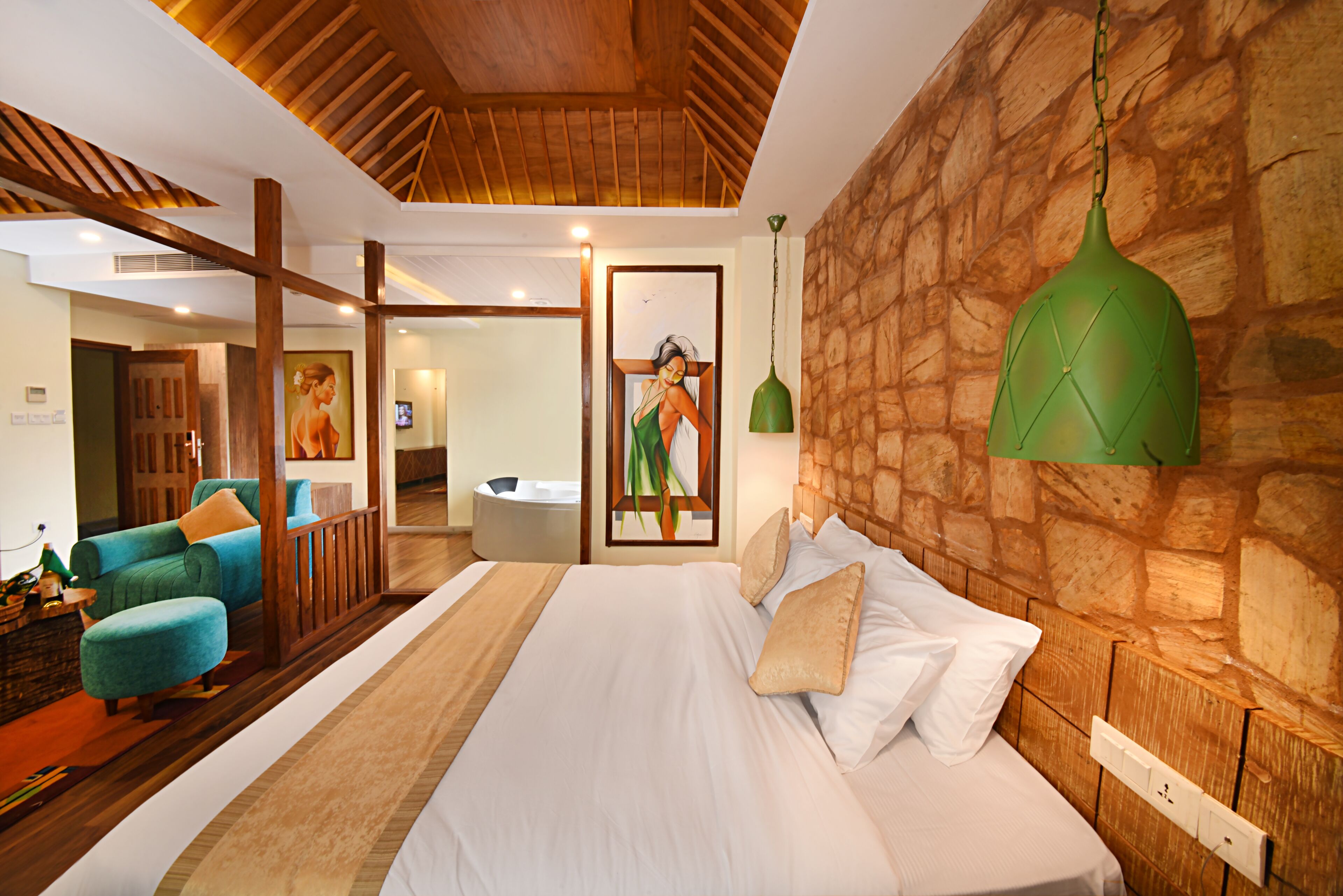 Een moderne hotelkamer met een groot bed, een houten hoofdeinde en een wand van natuursteen.
