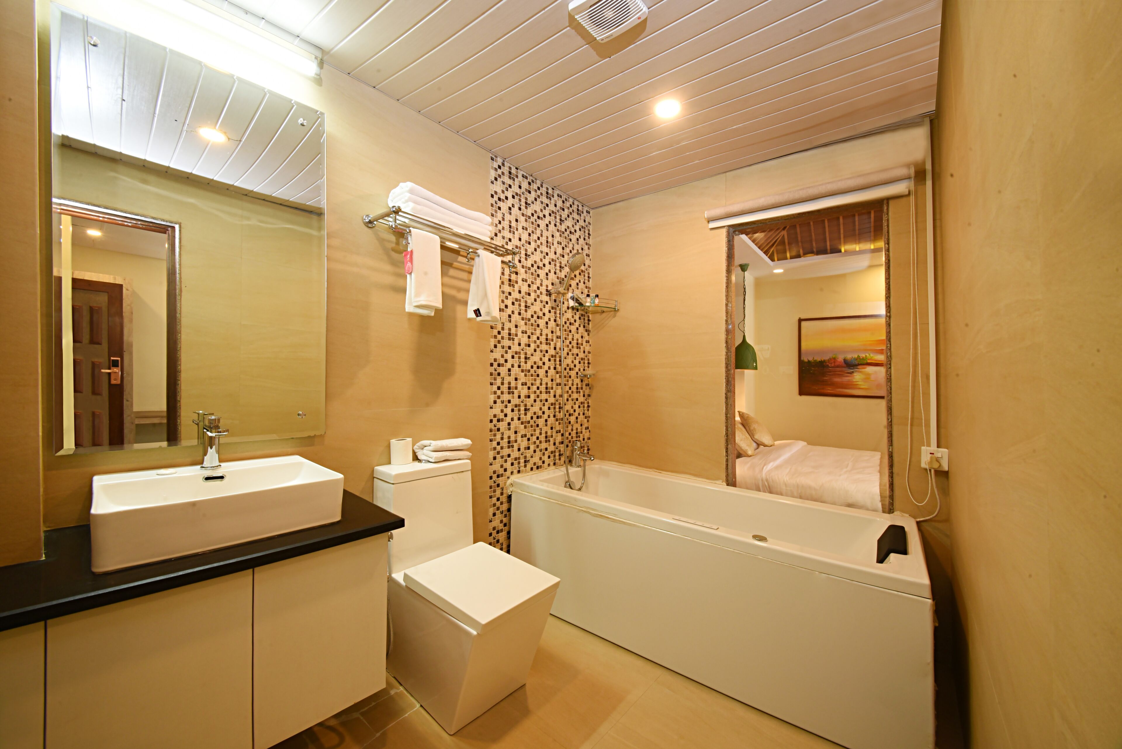 A modern bathroom with a sink, toilet, and bathtub.