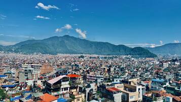 A densely populated urban area with a variety of building styles and a mountainous backdrop.