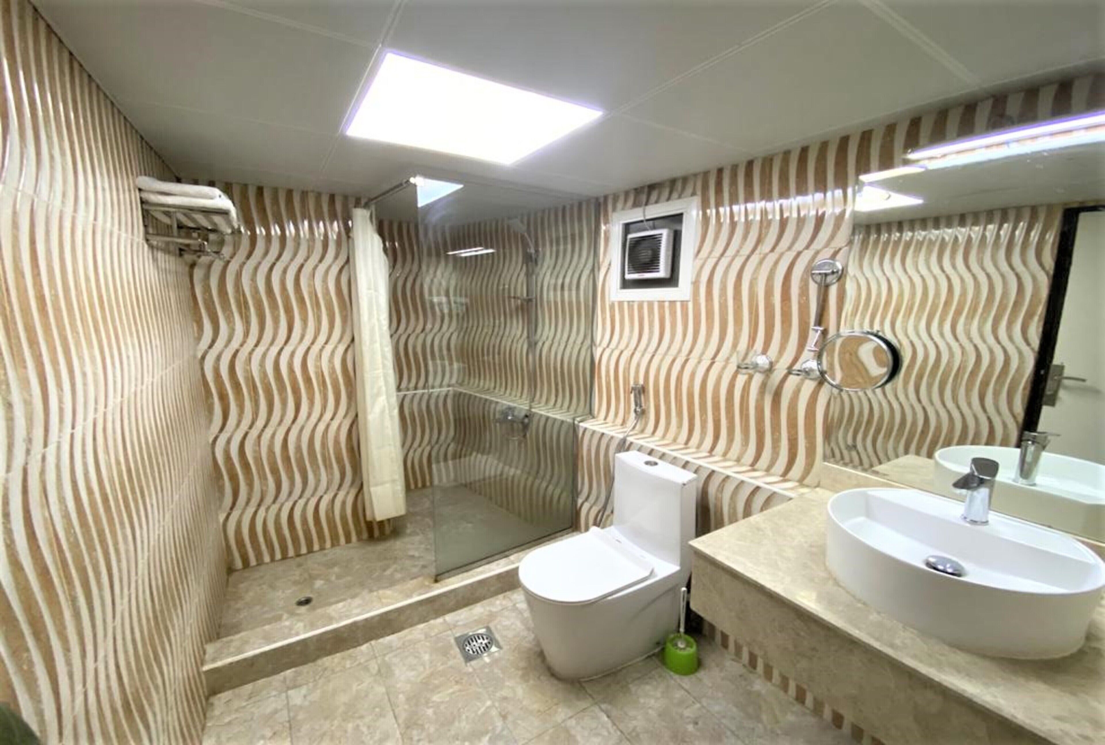 A bathroom with a shower, toilet, and sink.