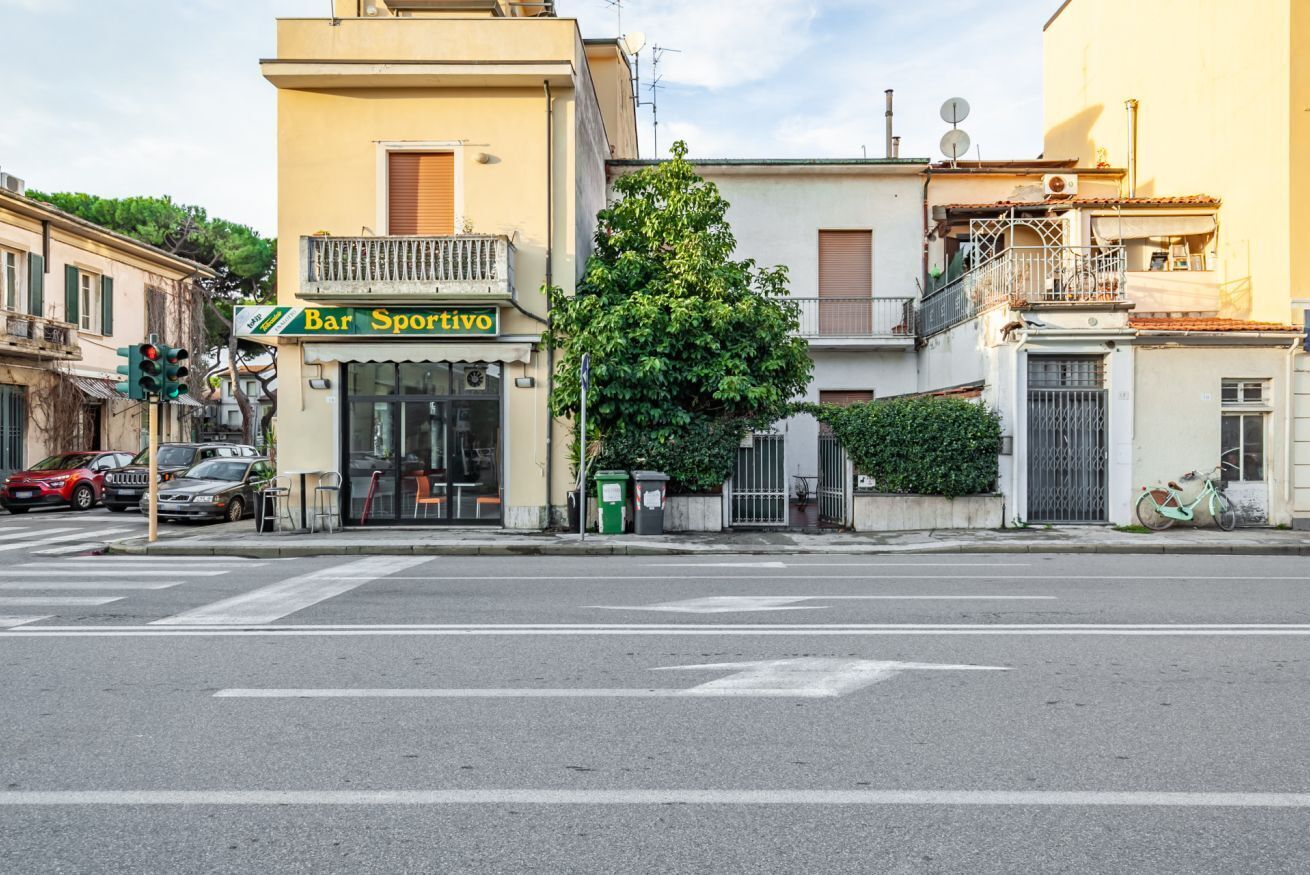 Vista de una calle con un bar llamado 'Bar Sportivo' en una intersección.