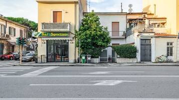 Vista de una calle con un bar llamado 'Bar Sportivo' en una intersección.