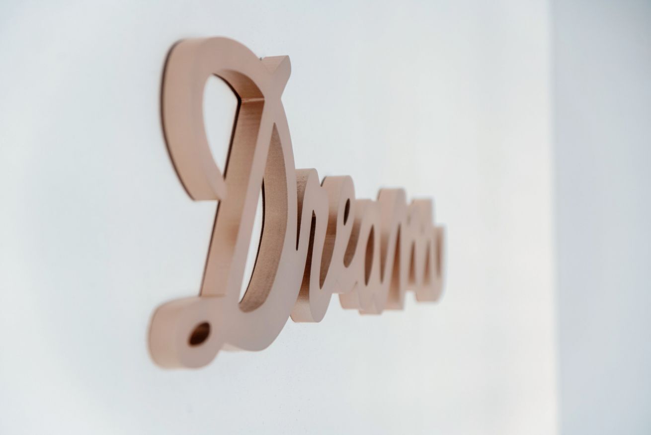 A wooden sign with the word "Dine" in a stylized font.