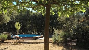 A backyard with a pool, a table, and chairs under a tree. - Roulotte with air conditioning and private pool in Tourtour (Tourtour)