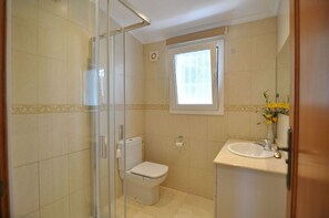 Ein Badezimmer mit Toilette, Waschbecken und Fenster.