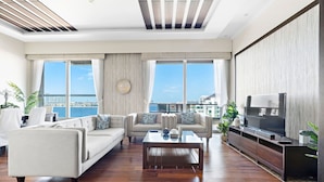 A modern living room with a sofa set, a coffee table, and a TV. - WelHome - Deluxe Apartment With Panoramic Sea Views (Dubai)