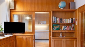 Een houten interieur met een televisie, een boekenkast en een wereldbol.