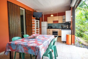 A compact kitchen with wooden cabinets, a microwave, and a sink. - Gites "villa bagatelle" ** 4/8 pers with swimming pool and SPA (Sainte-Rose)