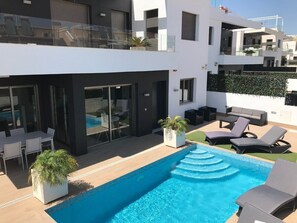A modern building with a rooftop pool, outdoor seating, and a glass balustrade. - Luxury villa with private pool (Orihuela Costa)