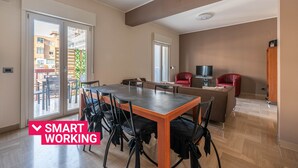 A modern living space with a dining area, a TV, and a red chair. - Appartamento Libertà con terrazza by Wonderful Italy (Palermo)