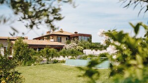 Una casa grande con un amplio jardín y piscina.