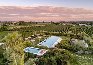 Un resort con dos piscinas rodeado de exuberantes jardines y palmeras.