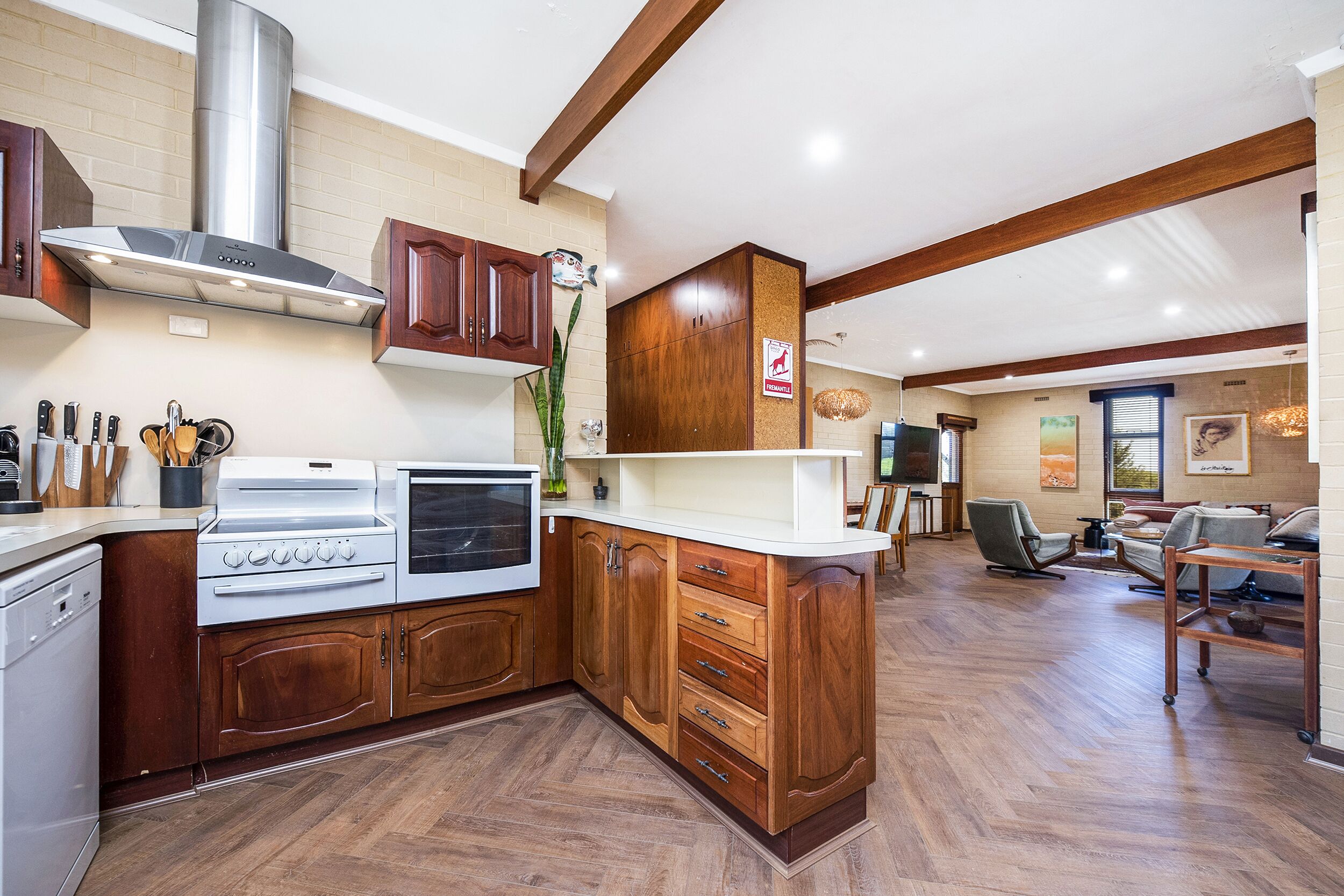 A kitchen with wooden cabinets, a stainless steel range hood, and a built-in oven.