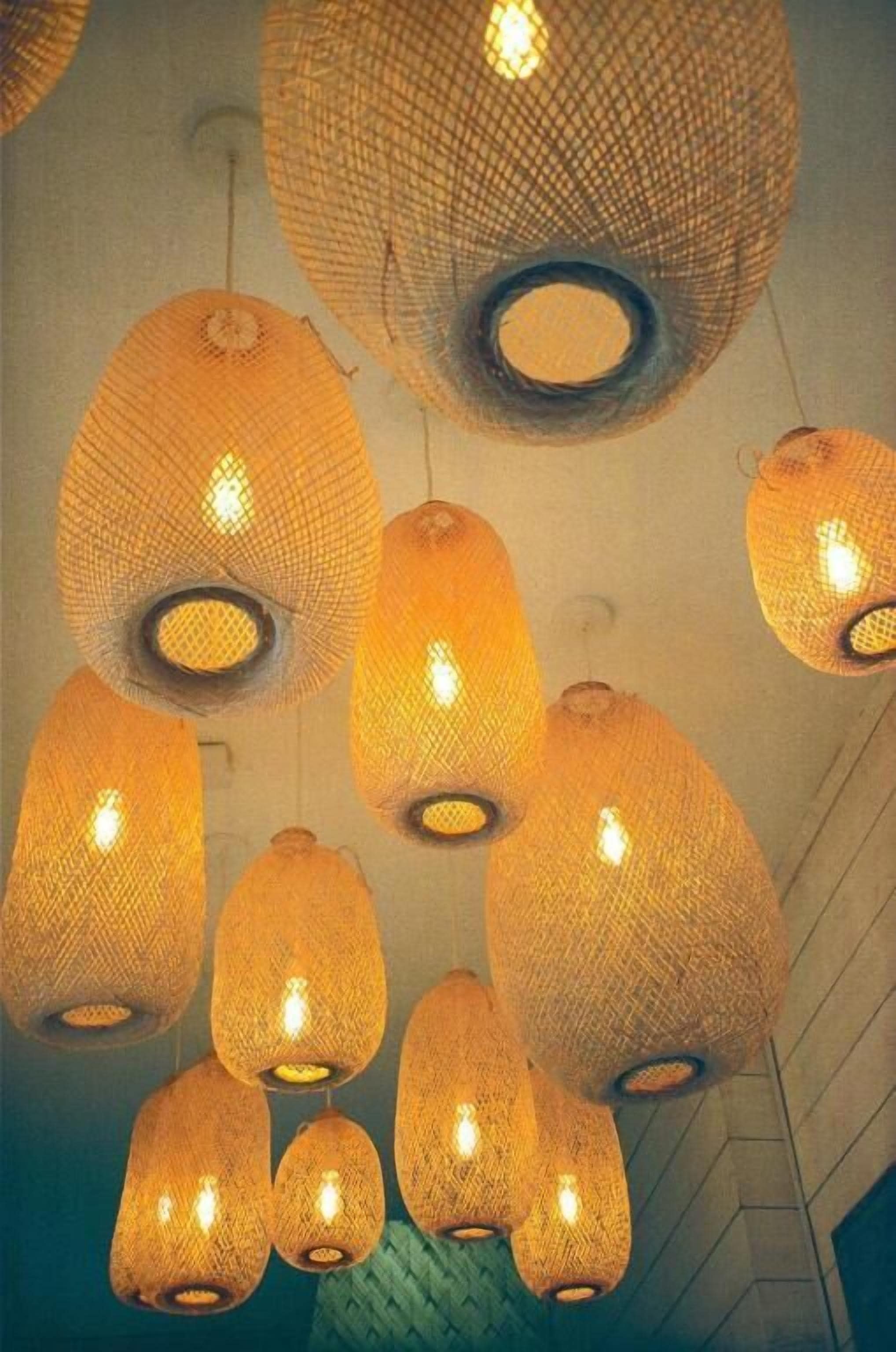 A ceiling with multiple hanging, woven light fixtures.