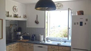 A kitchen with a window, a sink, a refrigerator, and a dishwasher. - Villa 90 m² panoramic view Nice, sea and mountains (Saint-Laurent-du-Var)