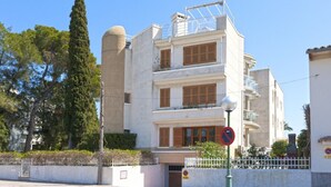 A multi-story building with a flat roof, large windows, and a white facade. - 2: GROUND FLOOR- APARTMENT ON THE SEA (Alcúdia)