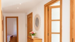 A hallway with wooden doors, a dresser, and a mirror. - 2: GROUND FLOOR- APARTMENT ON THE SEA (Alcúdia)