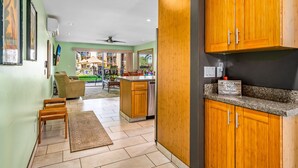 A modern kitchen with wooden cabinets, a granite countertop, and a sign indicating a guest book. - Hale Kamaole #170, Fully Renovated, Ground Floor, Full A/C, Near Kamaole III (Kihei)