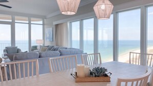 A dining area with a table, chairs, candles, and a decorative tray with a plant. - New Complex!! New to the Rentals Market.  Beachfront, Lazy River and Slide! (Orange Beach)