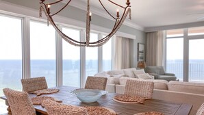 A dining area with a wooden table, woven placemats, and a central glass bowl. - New Complex!! Beachfront, Lazy River and Slide! Unmatched Views!! (Orange Beach)