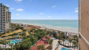 Een resort met zwembad, strand en uitzicht op zee.