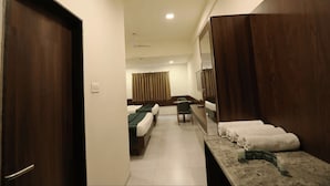 Habitación de hotel con dos camas, un escritorio, una silla y un baño con espejo.