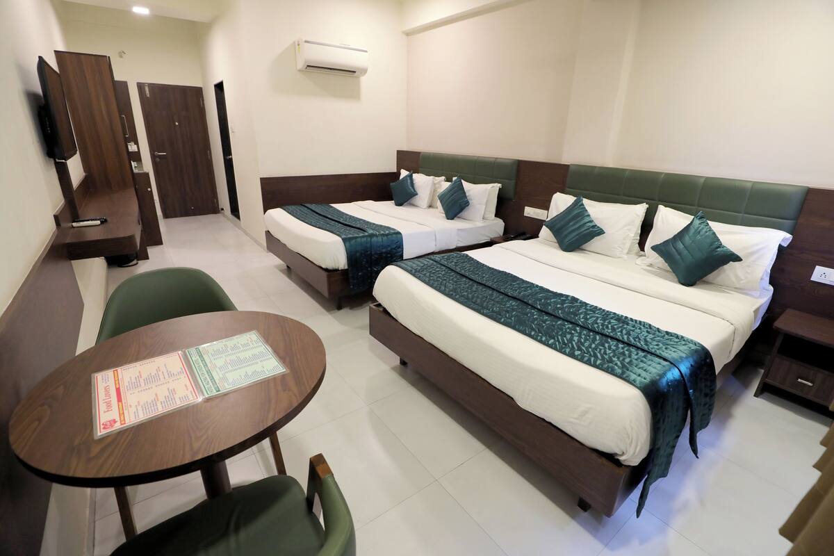 A hotel room with two beds, a desk, a chair, and a table with a menu.