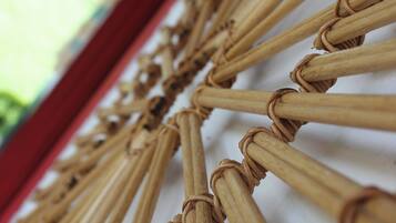 Een close-up van een geweven bamboestructuur, waarschijnlijk onderdeel van een kamerinrichting of meubilair.