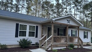 A single-story house with a porch, a front door, and a small front yard.