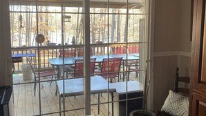 A room with a large sliding glass door leading to an outdoor patio with tables and chairs.