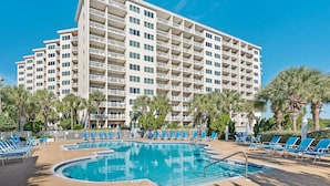 A hotel with multiple floors, a swimming pool, and palm trees. - Tops'l Summit 812 ~ Gulf views and quick walk to the beach (Miramar Beach)
