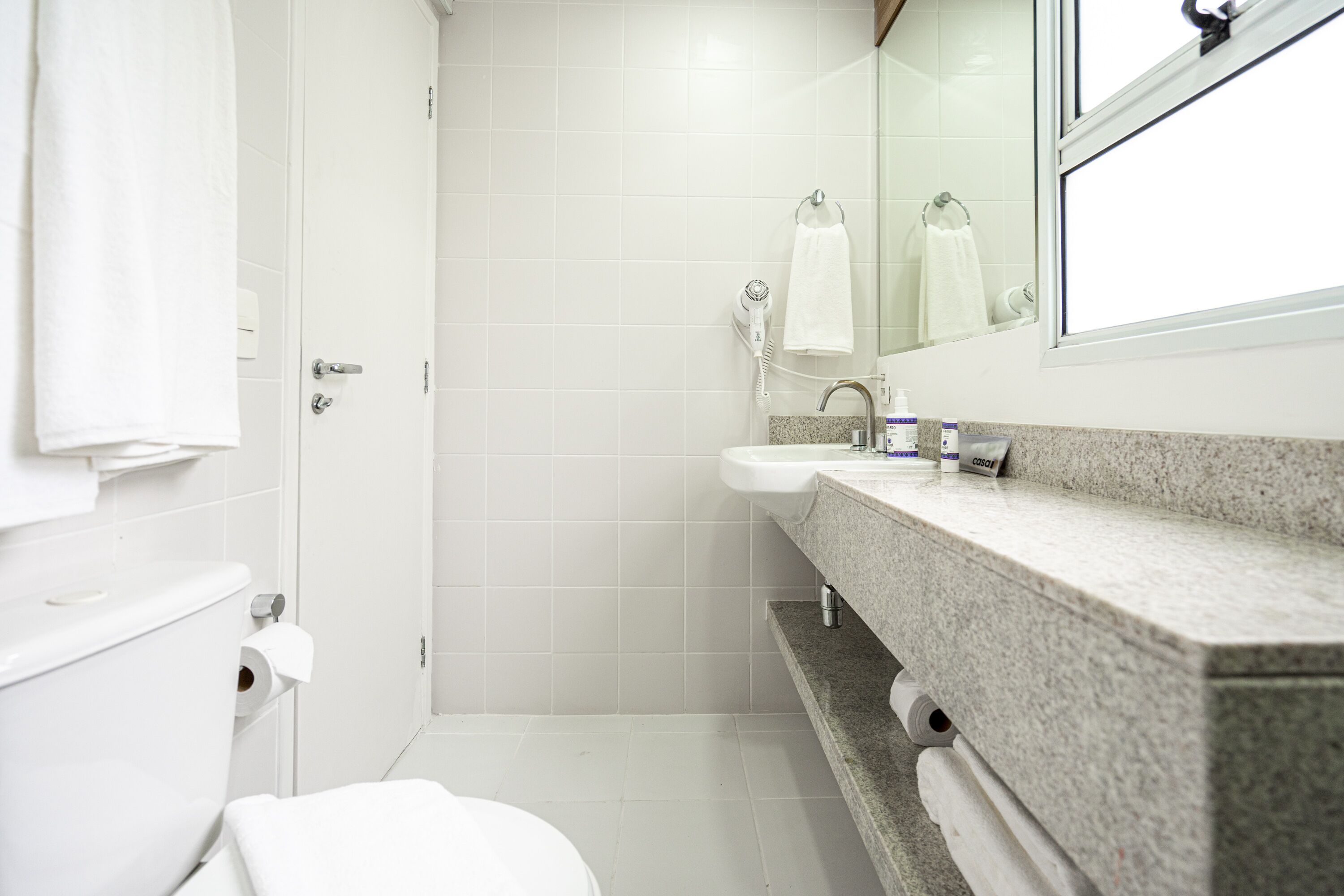 A bathroom with a toilet, sink, and shower.