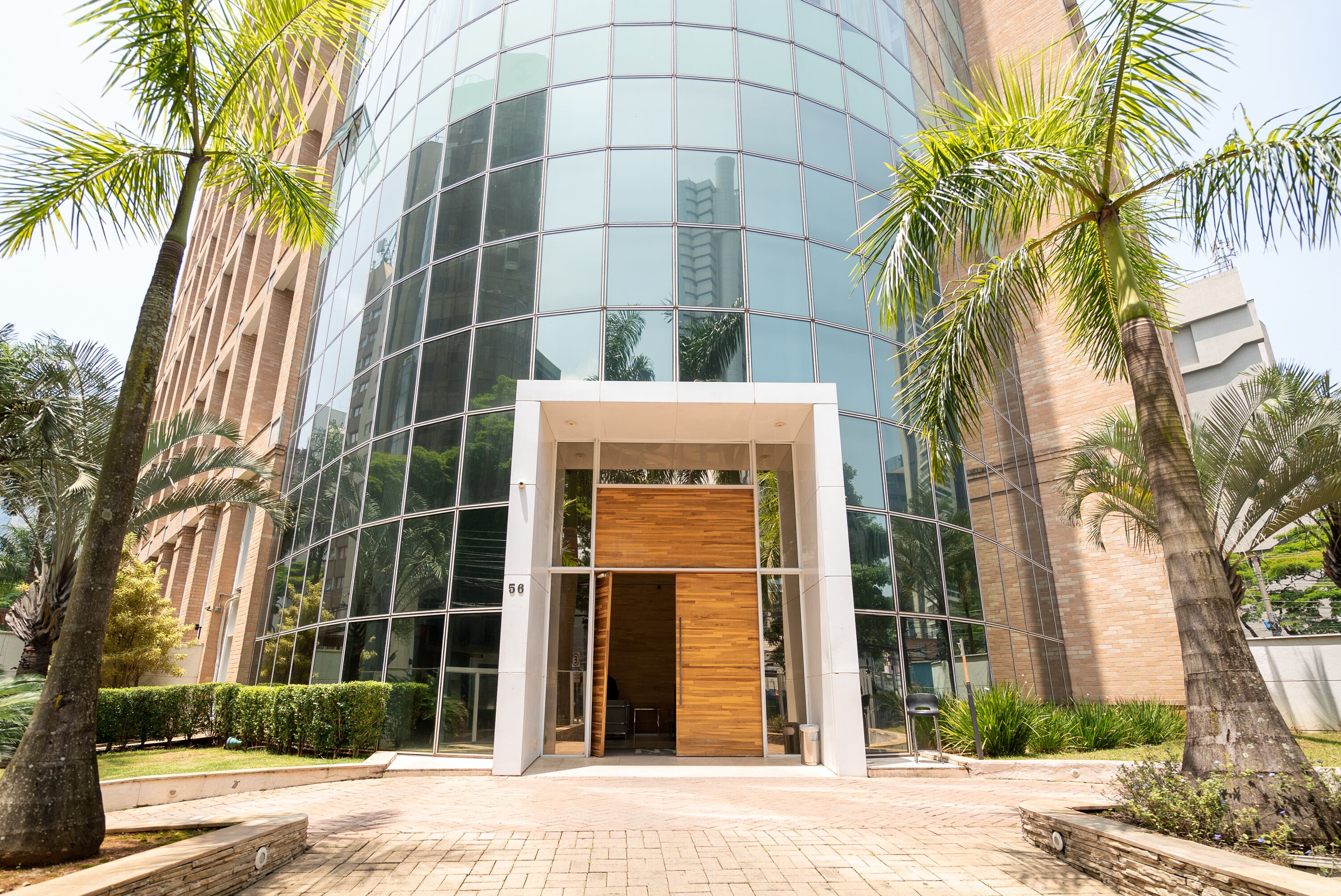 A modern building with a glass facade and a wooden entrance.