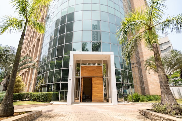 A modern building with a glass facade and a wooden entrance. - Charlie NYC Berrini (São Paulo)