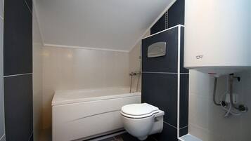 Un baño con bañera, inodoro y ducha empotrada.