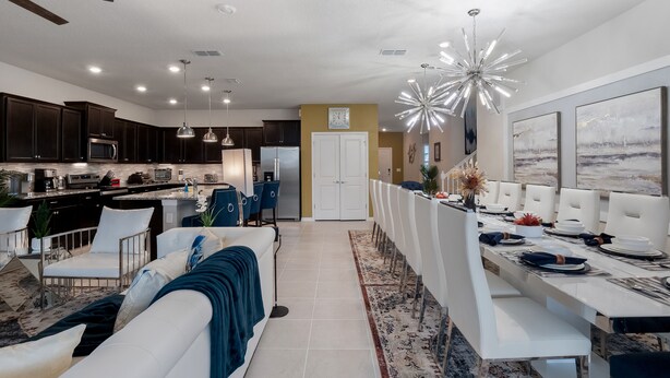 A modern kitchen with dark cabinets, stainless steel appliances, and pendant lighting. - PROMO Elegant 9 BR Villa, Pool/Spa, Resort - by Blue Sky Villas (Davenport)