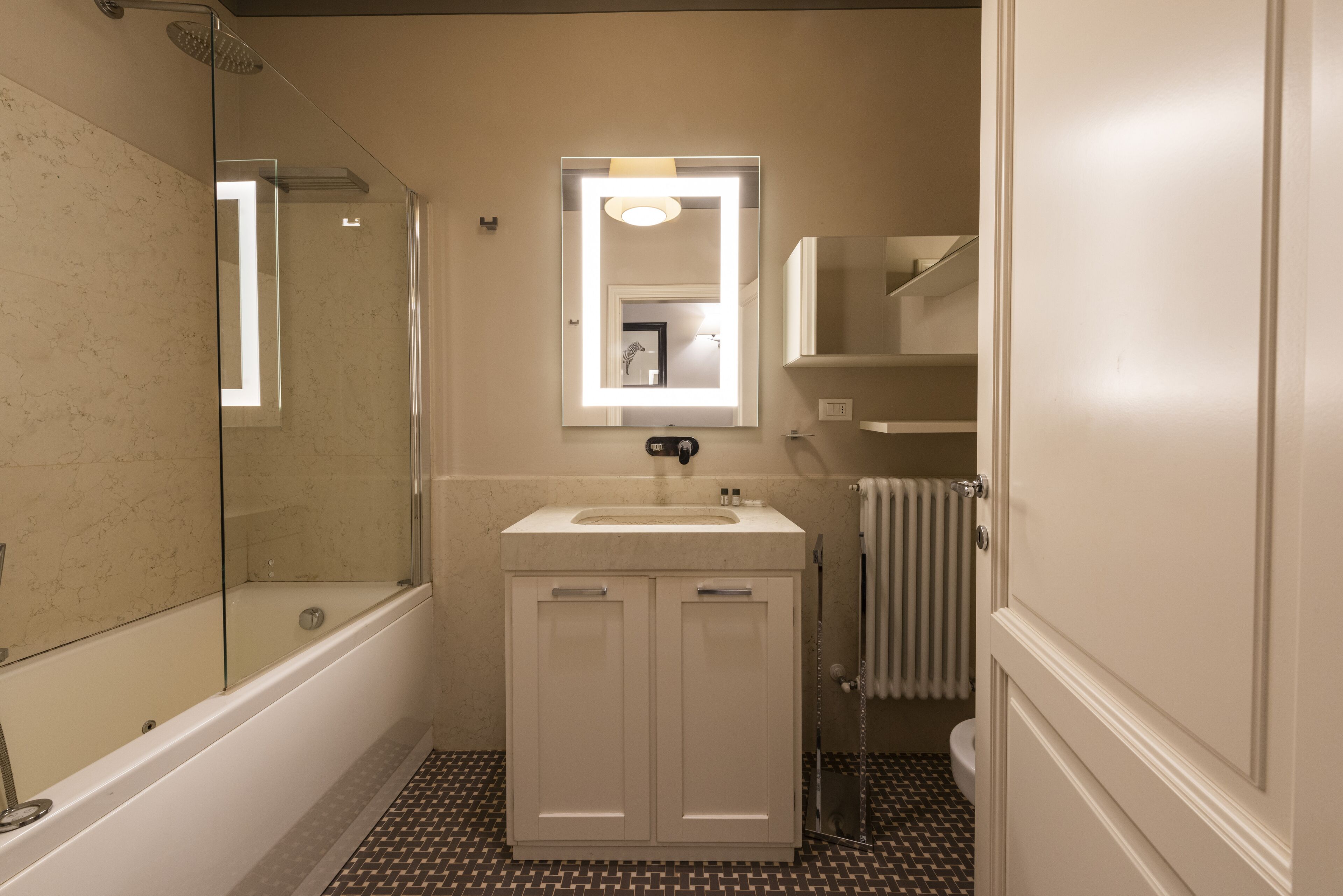 Une salle de bain avec une baignoire, un lavabo avec un miroir au-dessus et des toilettes.