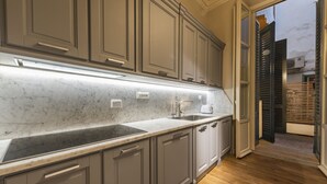 Uma cozinha moderna com bancadas de mármore, armários embutidos e piso de madeira.