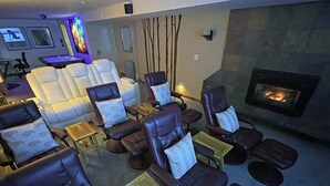 Eine Lounge mit Ledersofas und Sesseln, einem Kamin und einem kleinen Tisch mit Kerze.