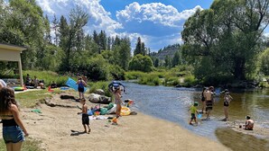 Eine Flusslandschaft, auf der sich Menschen verschiedenen Aktivitäten widmen.