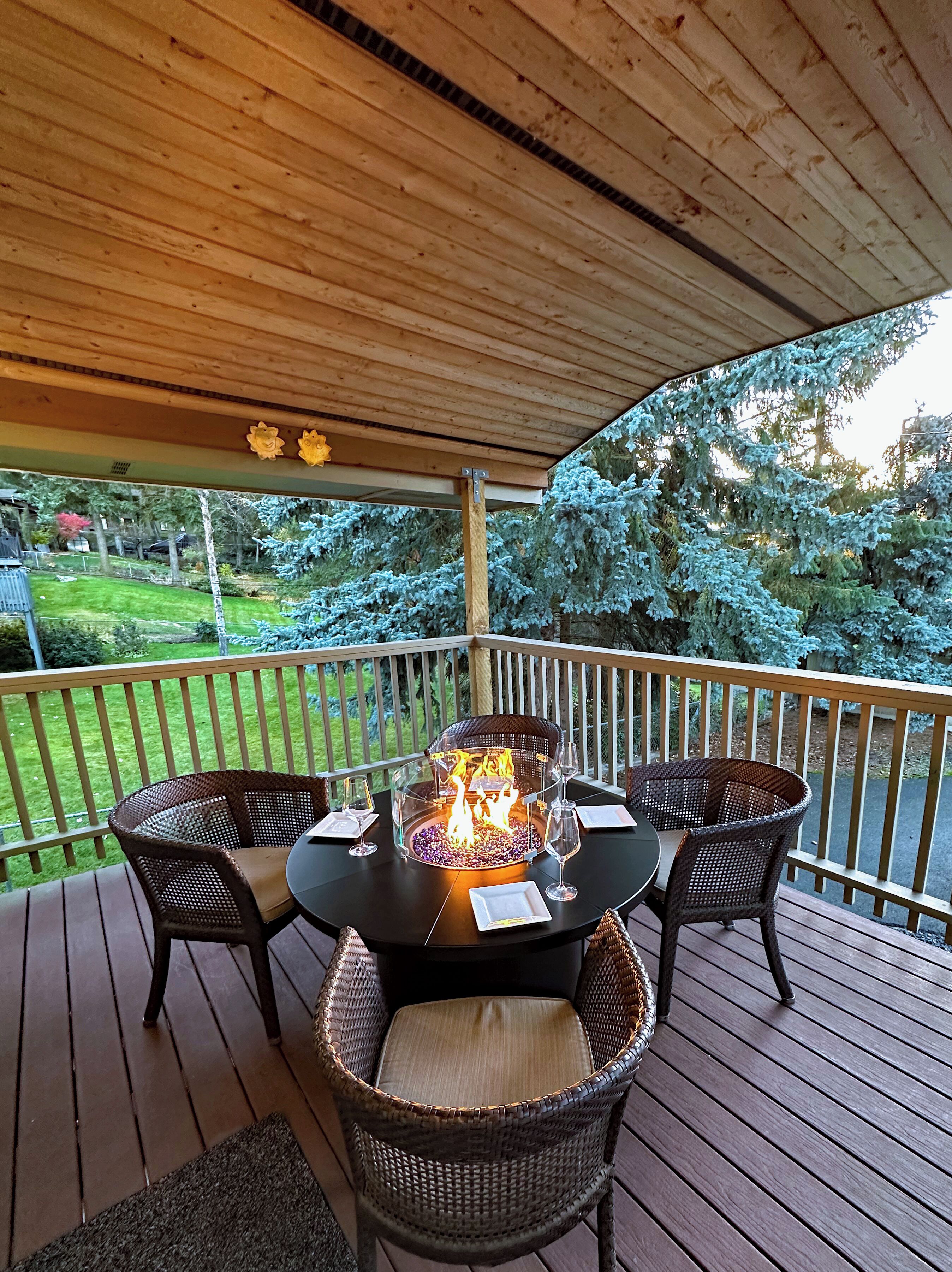 ALL WEATHER COVERED PATIO  -  Feel flames warm our GLASS FIRE-PIT DINING TABLE.