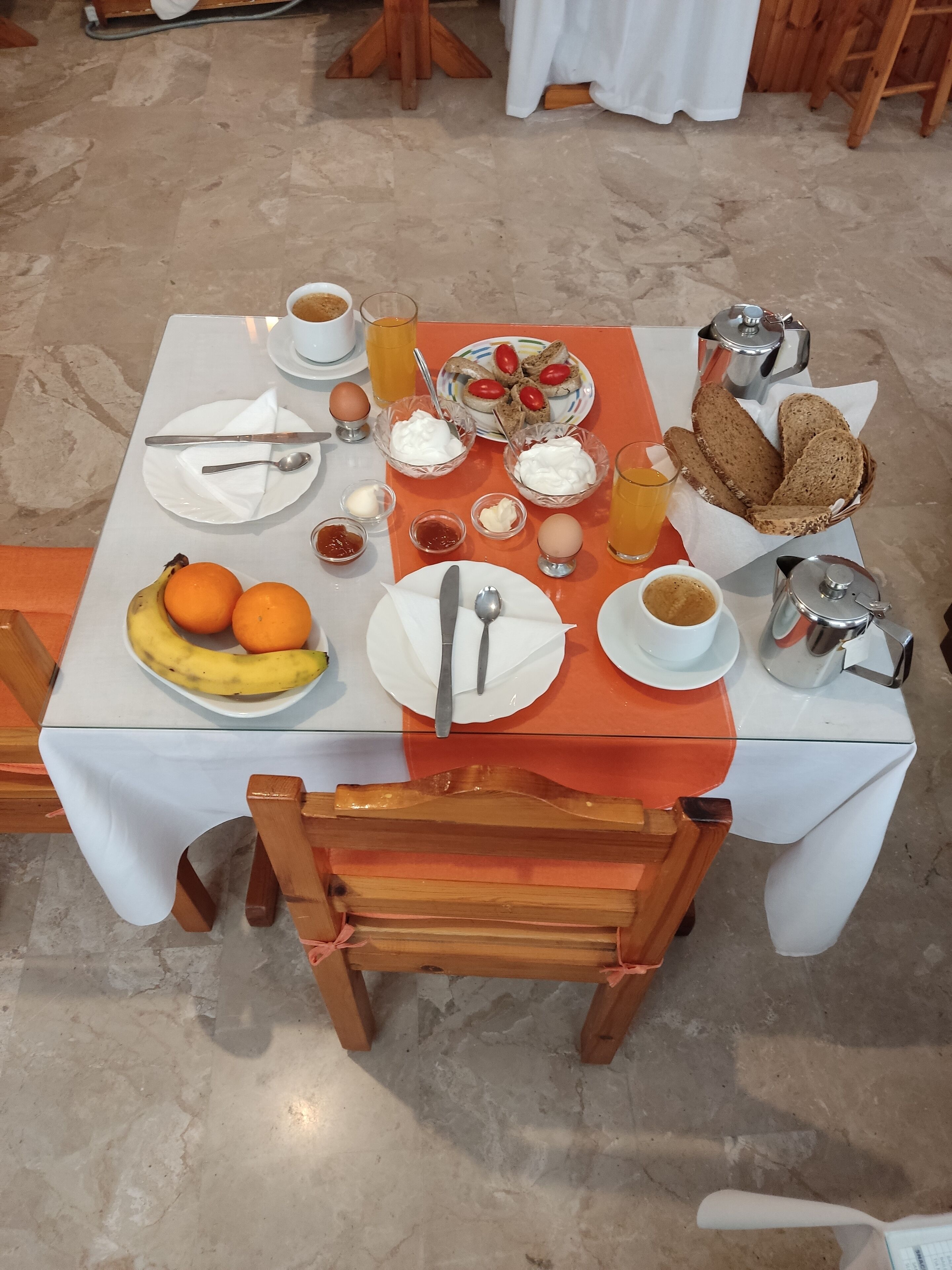 Una mesa de desayuno con platos, tazones y tazas.