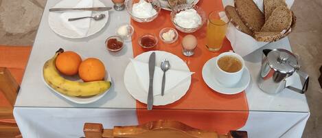Una mesa de desayuno con platos, tazones y tazas.