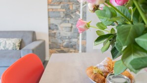 A dining table with a vase of flowers and pastries.