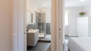 A modern bathroom with a shower, sink, and mirror.