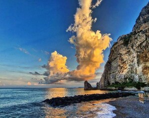 A coastal landscape with a prominent cliff and a rock formation in the sea. - Residenza Mare di Sotto Sorrento (Meta)