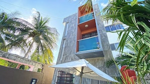 A multi-story building with a modern design, featuring balconies and large windows.